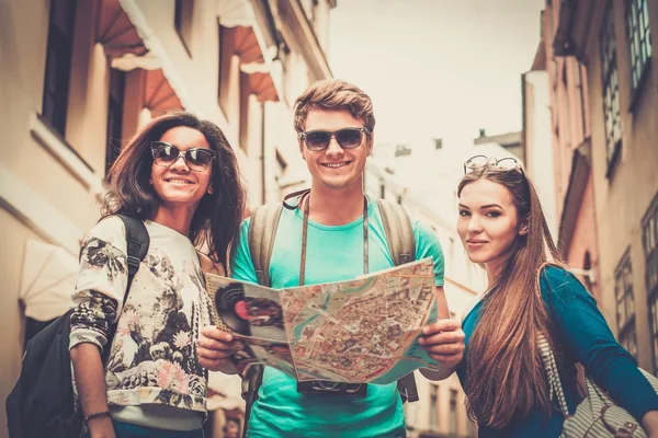 Multi ethnic friends tourists with map in old city