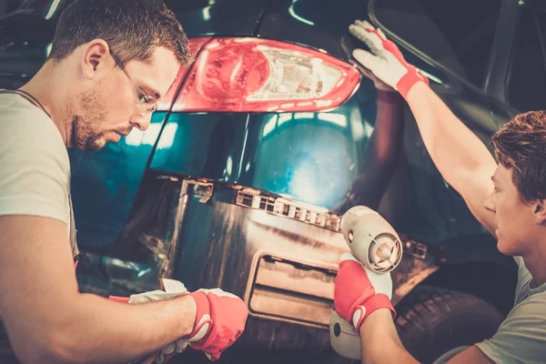 Deux travailleurs avec des échantillons de couleur choisissant le ton correct dans un atelier de carrosserie — Photo