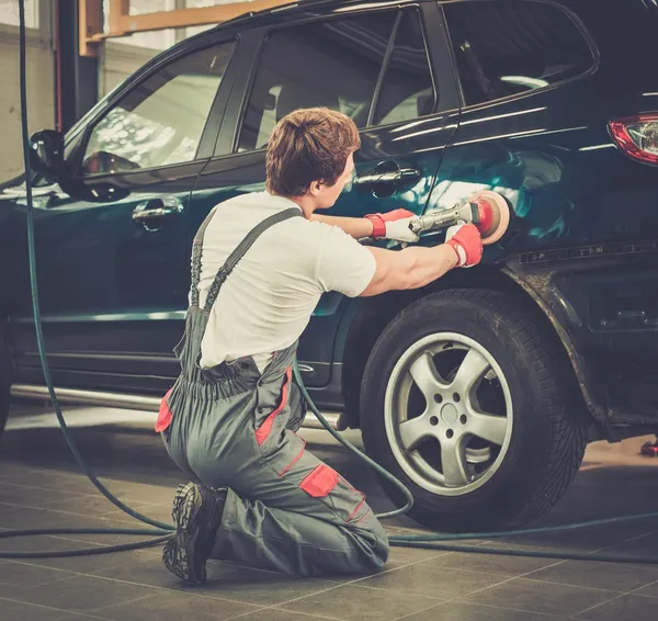 Serviceman lucidatura carrozzeria con macchina in officina — Foto Stock