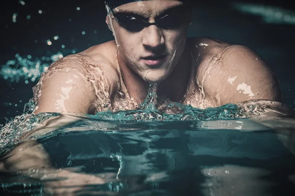 Joven musculoso en gorra azul en piscina — Foto de Stock