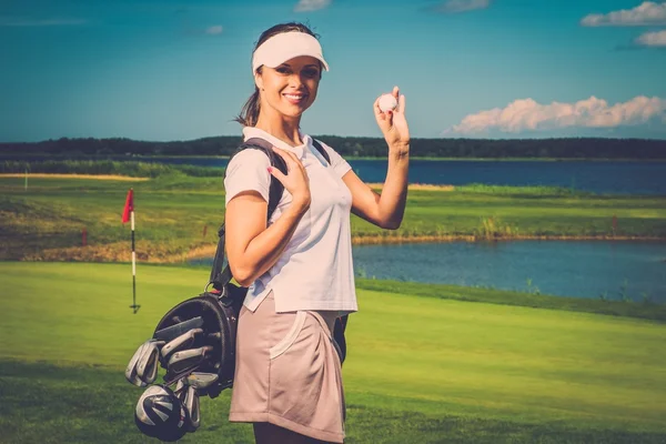 Жінка з сумкою і м'ячем на полі для гольфу — стокове фото