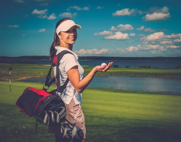 Junge fröhliche Frau mit Tasche und Ball auf einem Golfplatz — Stockfoto