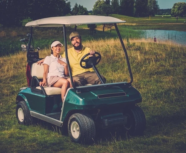 Pareja feliz conduciendo carrito de golf — Foto de Stock