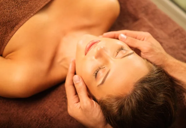 Jovem mulher fazendo massagem facial em um salão de spa — Fotografia de Stock