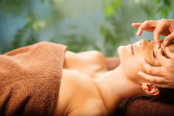 Genç bir kadın olan bir spa salonu masaj yüz — Stok fotoğraf