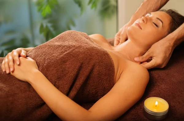 Jovem mulher fazendo massagem facial em um salão de spa — Fotografia de Stock