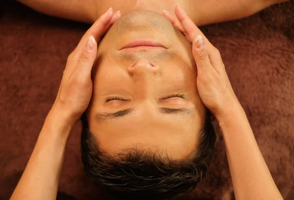 Pohledný muž s tváří masáž ve wellness salonu — Stock fotografie