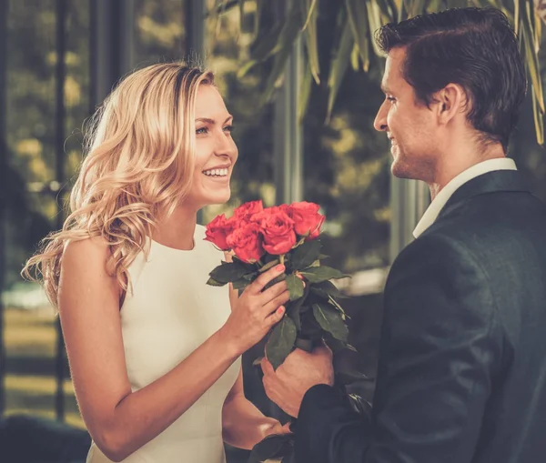 Handsome man with bunch of red roses dating his lady — Stock Photo, Image