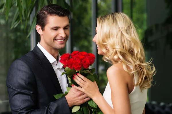 Schöner Mann mit einem Strauß roter Rosen aus der Zeit seiner Frau — Stockfoto