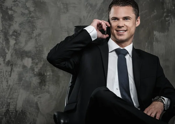 Hombre bien vestido en traje negro con teléfono móvil — Foto de Stock