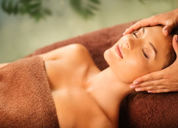 Jovem mulher fazendo massagem facial em um salão de spa — Fotografia de Stock