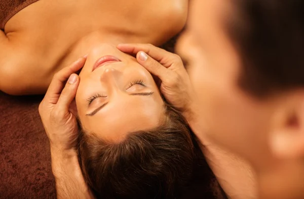 Jonge vrouw met gezicht massage in een spa salon — Stockfoto