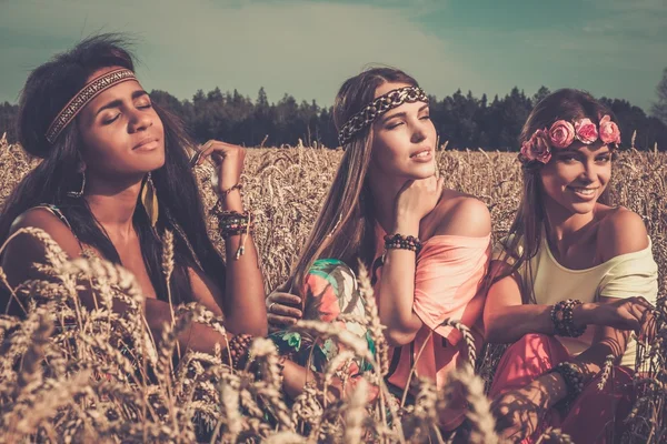 Multietniska hippie flickor i ett vete fält — Stockfoto