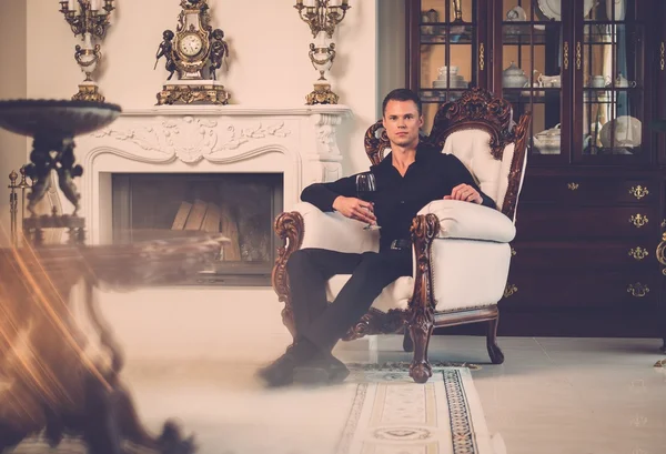 Człowiek siedzi w luksusowy dom — Zdjęcie stockowe