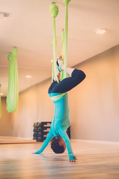 Jonge vrouw uitvoeren van anti-zwaartekracht yoga oefening — Stockfoto