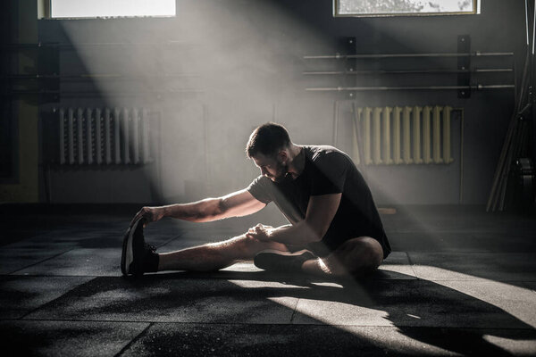 Athletic Man Stretch His Legs . Royalty Free Stock Images
