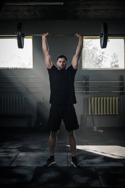 Sportsman Lift Heavy Barbell and Look at Camera . Stock Photo