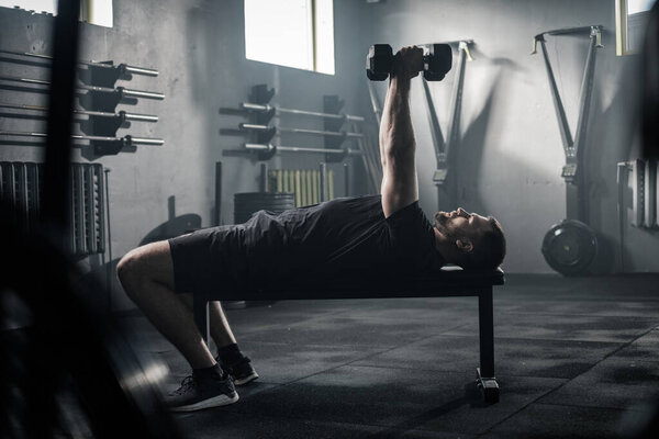 Fitness Man Has Training at Gym With Dumbbells . Stock Photo
