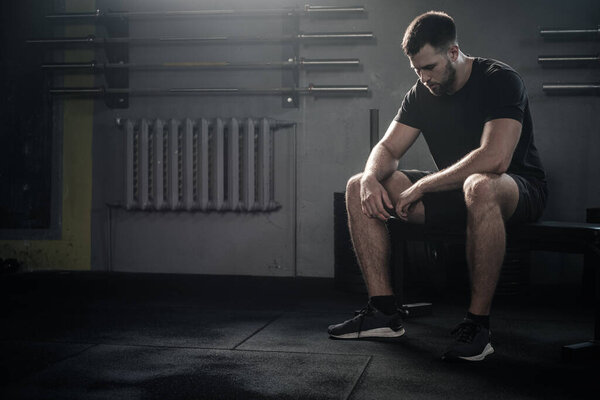Tired Sportsman Sit on Bench After Workout . Stock Photo