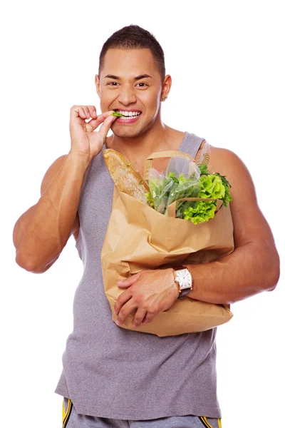 Портрет сексуального мужчины, позирующего в студии с овощами — стоковое фото