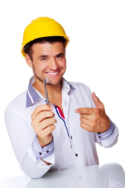 Porträt eines gut aussehenden Arbeiters, der mit Helm und Schlüssel im Studio posiert — Stockfoto