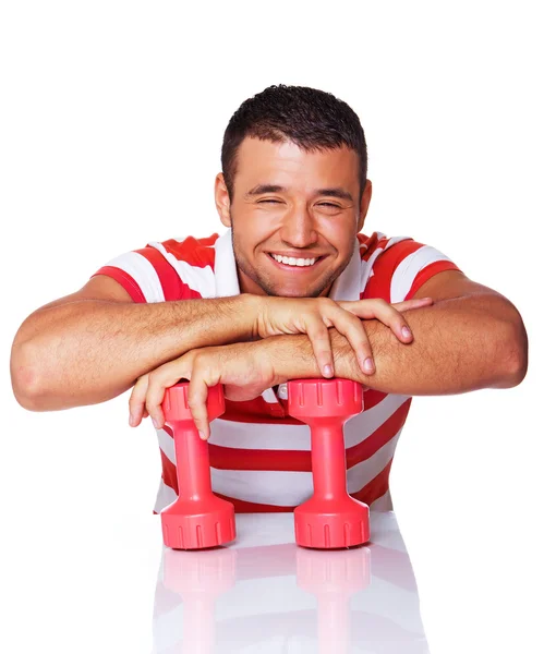 Portrait of smiling man posing in studio with dumbbells — Stock Photo, Image