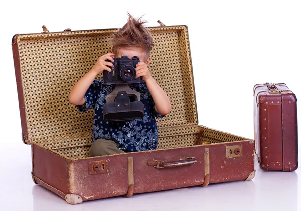 Portrét pohledný kluk pózuje na bílém pozadí s fotoaparátem — Stock fotografie