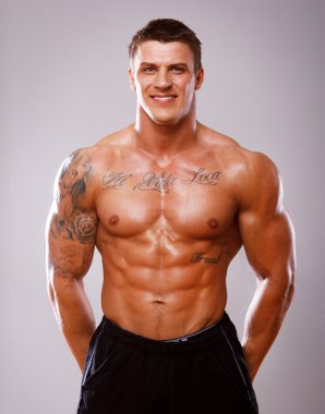 Beyaz arka plan üzerinde poz yakışıklı vücut geliştirmeci portresi