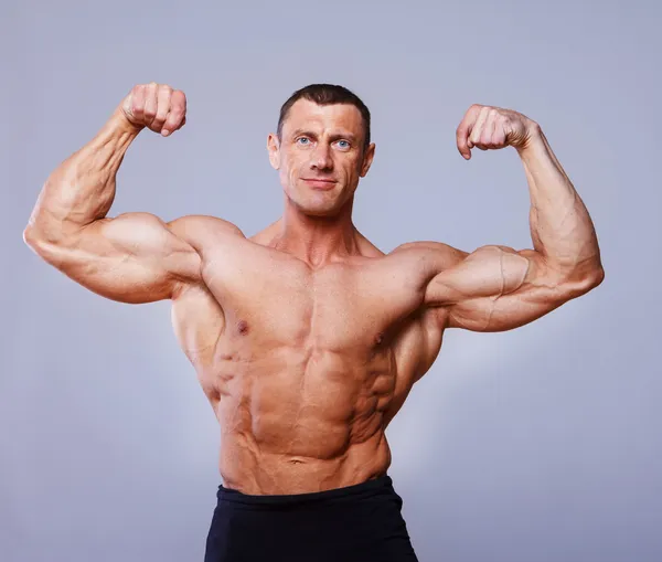 Portrait of handsome bodybuilder posing on white background - Stock Image -  Everypixel