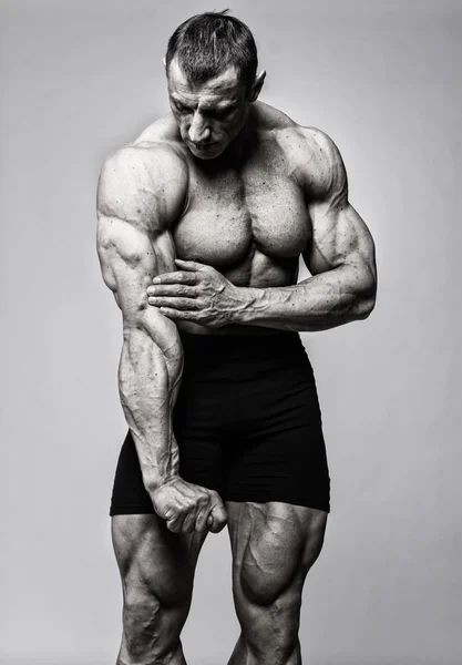 Portret van knappe bodybuilder poseren op witte achtergrond — Stockfoto