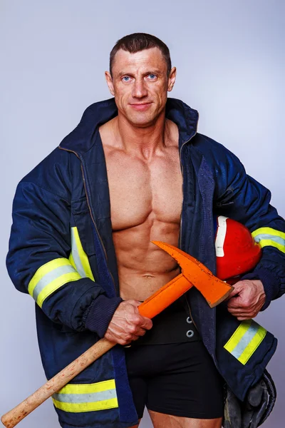 Portret van knappe brandweerman die zich voordeed op witte achtergrond — Stockfoto