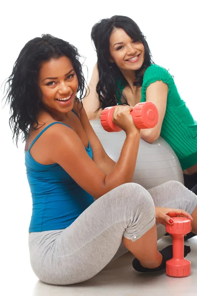 Portrait of 2 beautiful girl posing in studio with dumbbells — Stock Photo, Image