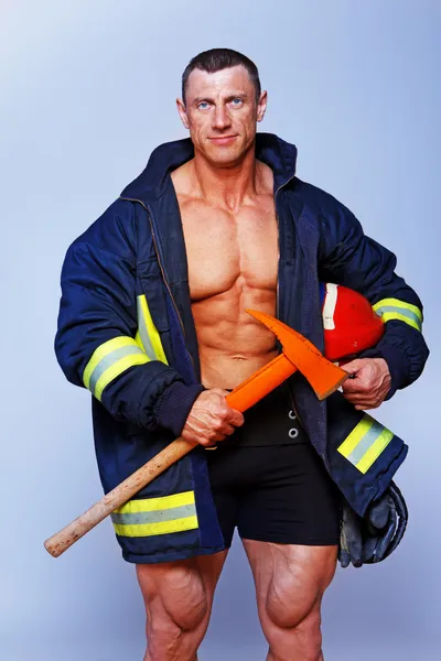 Portrait of handsome man posing on black background in fireman c — Stock Photo, Image