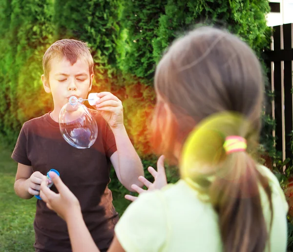 Retrato de niños posando sobre hierba y sonriendo — Foto de Stock