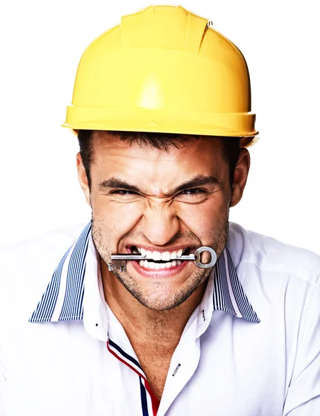 Retrato de belo trabalhador posando em estúdio com capacete e chave — Fotografia de Stock