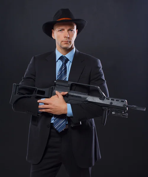 Hombre está posando en el suelo con un arma —  Fotos de Stock