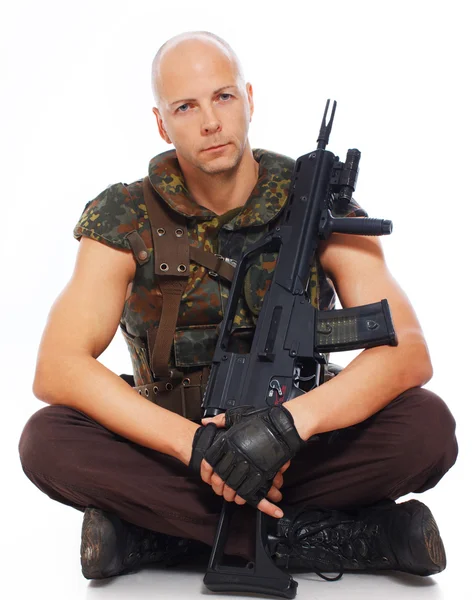 Hombre está posando en el suelo con un arma — Foto de Stock