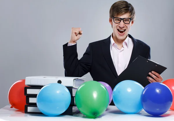 Portrait of handsome man posing on grey background with balloon — Stock Photo, Image