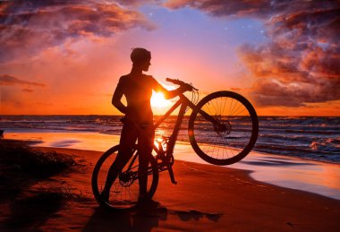 Woman with bicycle on the beach clipart