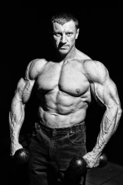 büyük kas adam için photoshoot dumbbells ile poz veriyor