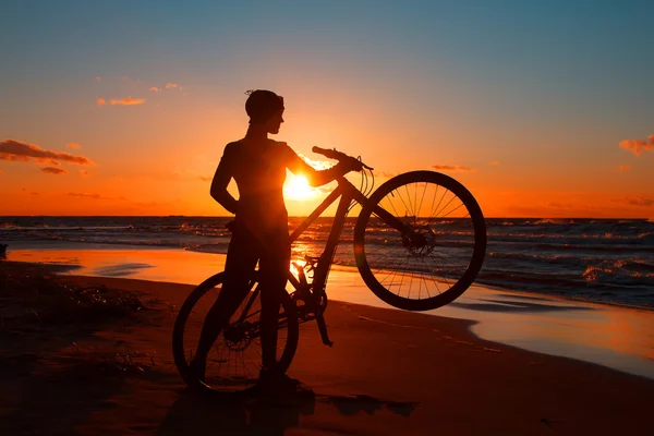Woman with a bicycle on the sea — Stock Photo, Image