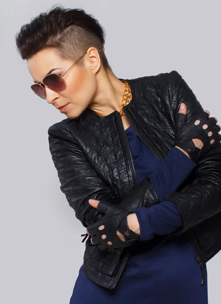 Trendfrau in Lederjacke und Sonnenbrille posiert für ein Foto — Stockfoto