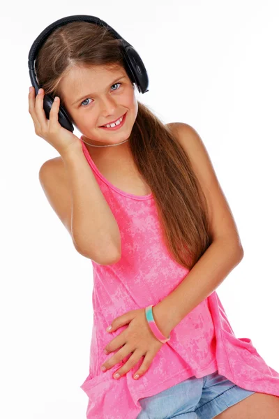 Attractive girl is holding headphone while listening music — Stock Photo, Image