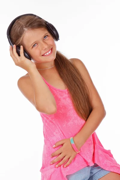 Menina sorridente está segurando fone de ouvido e ouvir música — Fotografia de Stock