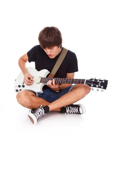 Sentado en el piso chico está jugando en la guitarra —  Fotos de Stock