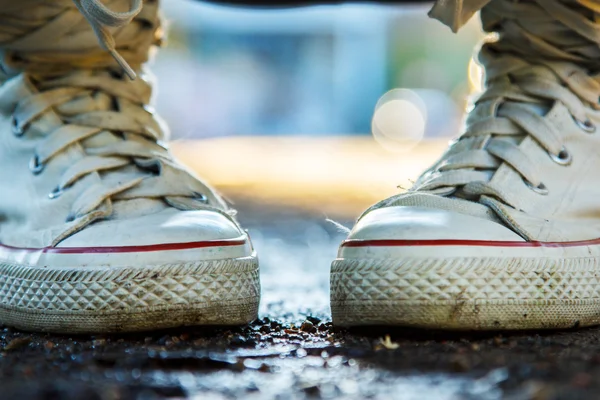 Zoomed white and high girlish gumshoes — Stock Photo, Image