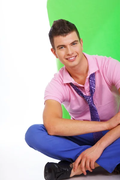 Cara encantador com um sorriso bonito sentado no chão — Fotografia de Stock