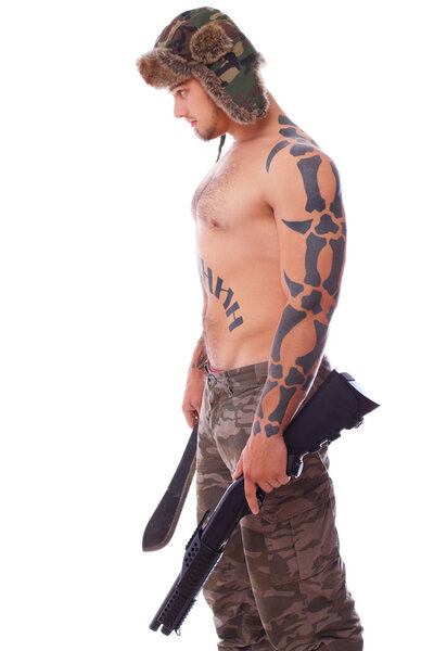 Русский парень стоит слева и держит пистолет и макароны.
