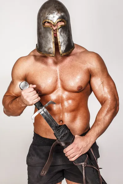 Nude barbarian in helmet and with sword — Stock Photo, Image