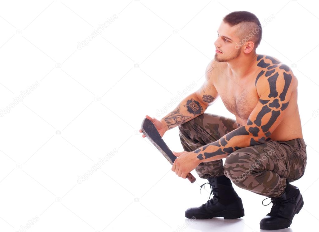 Russian man with machete is sitting and leaning on his feets